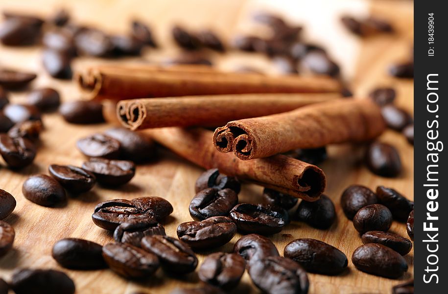 Cinnamon with coffee beans on wooden board