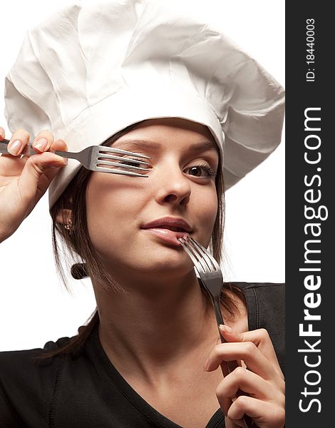 Portrait of a pretty young smiling  uniformed female Chef looking through forks