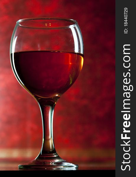 Red vine in glass on vintage red background