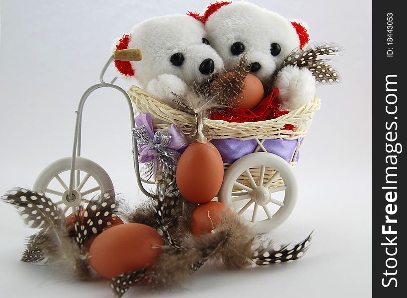 Two white teddy bears with an Easter eggs and with feather. Two white teddy bears with an Easter eggs and with feather