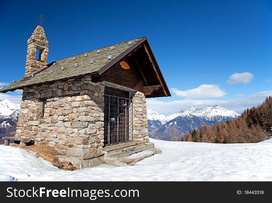 A small chapel in the mountains during winter. Mortirolo Pass, Lombardy region, Italy