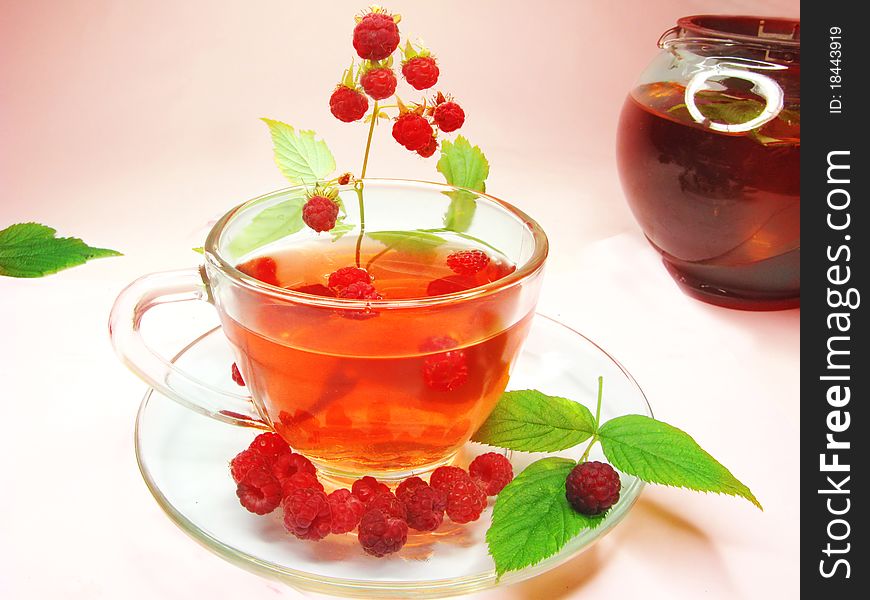 Fruit red tea with raspberry berries in cup and teapot. Fruit red tea with raspberry berries in cup and teapot