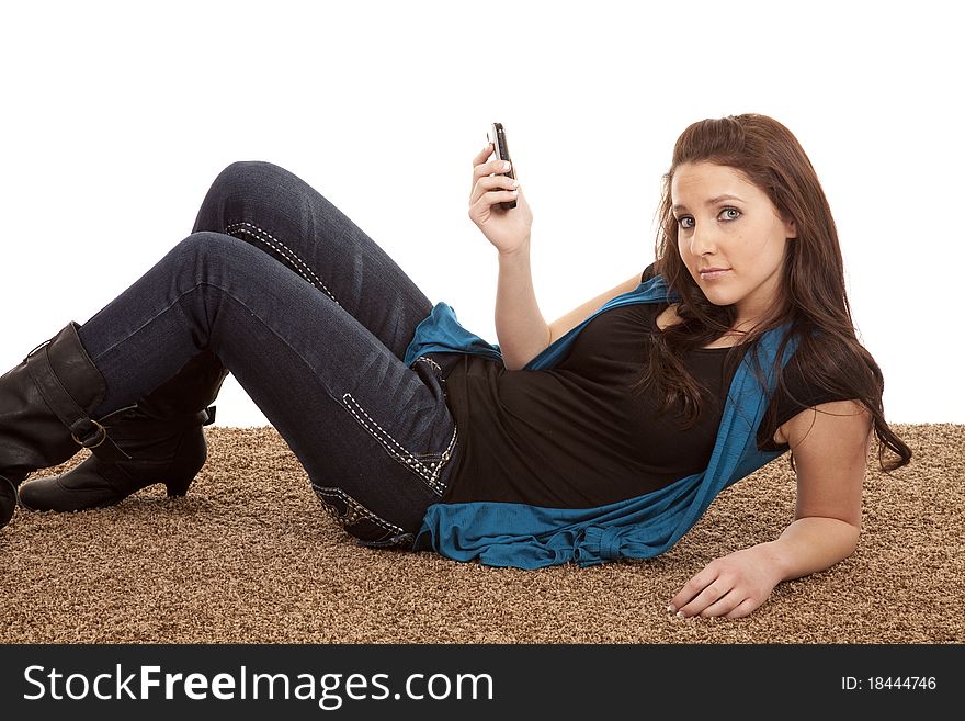 A woman is laying on the floor with her phone. A woman is laying on the floor with her phone.