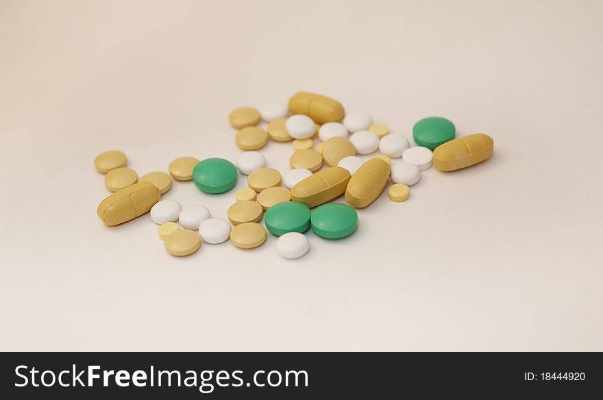 Many multi-colored tablets lie on a white background (small depth of sharpness)