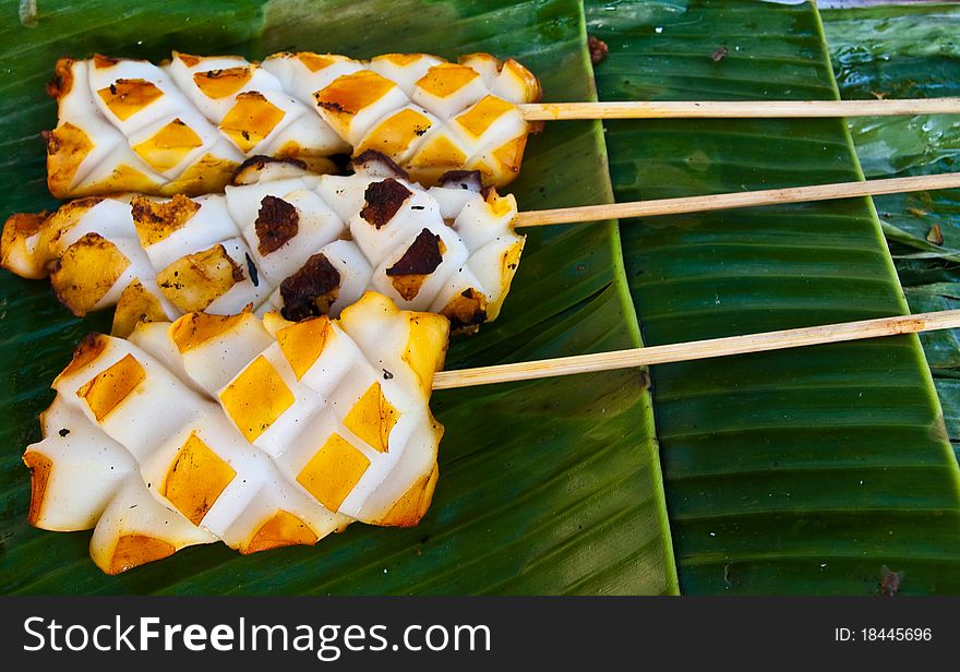 Three of grilled squid on banana leaves ready for eat