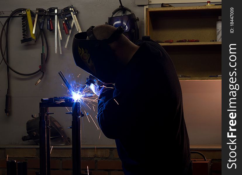 Welder in workshop welding metalic details