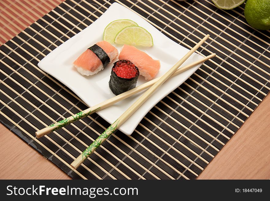 Japanese sushi with chopsticks on bamboo mat