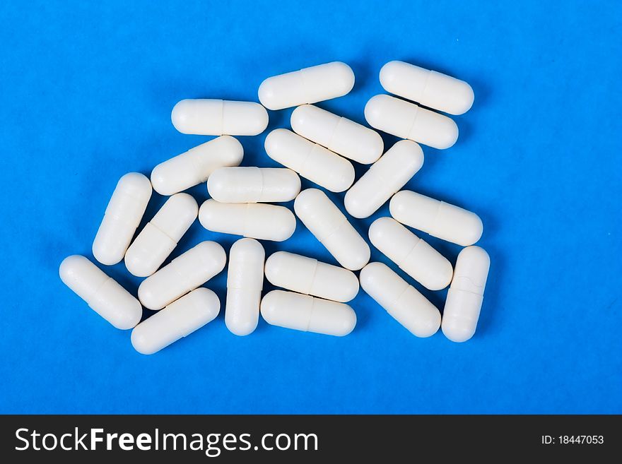 Macro view of white pills on a blue background