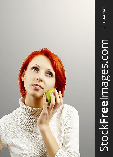 The girl holding an apple in a hand on the isolated white background. The girl holding an apple in a hand on the isolated white background