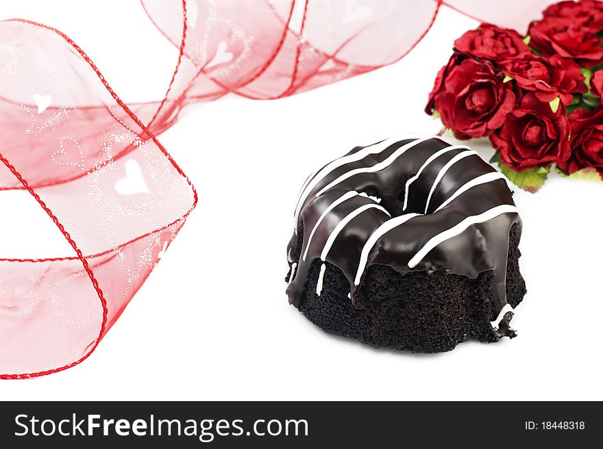 A dark chocolate Valentines cake with ribbon and roses, white background