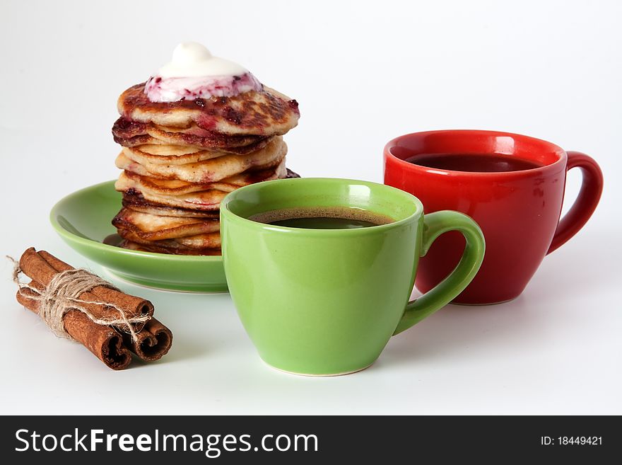 Delicious pancakes with sour cream and jam and two cups of coffee. Delicious pancakes with sour cream and jam and two cups of coffee