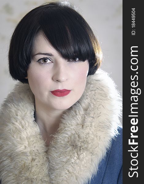 Close up of photo of a beautiful dark-haired young woman wearing a coat with a fake fur collar. Close up of photo of a beautiful dark-haired young woman wearing a coat with a fake fur collar.