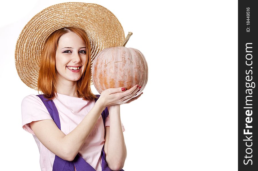 Young girl in overalls with pumpkin.