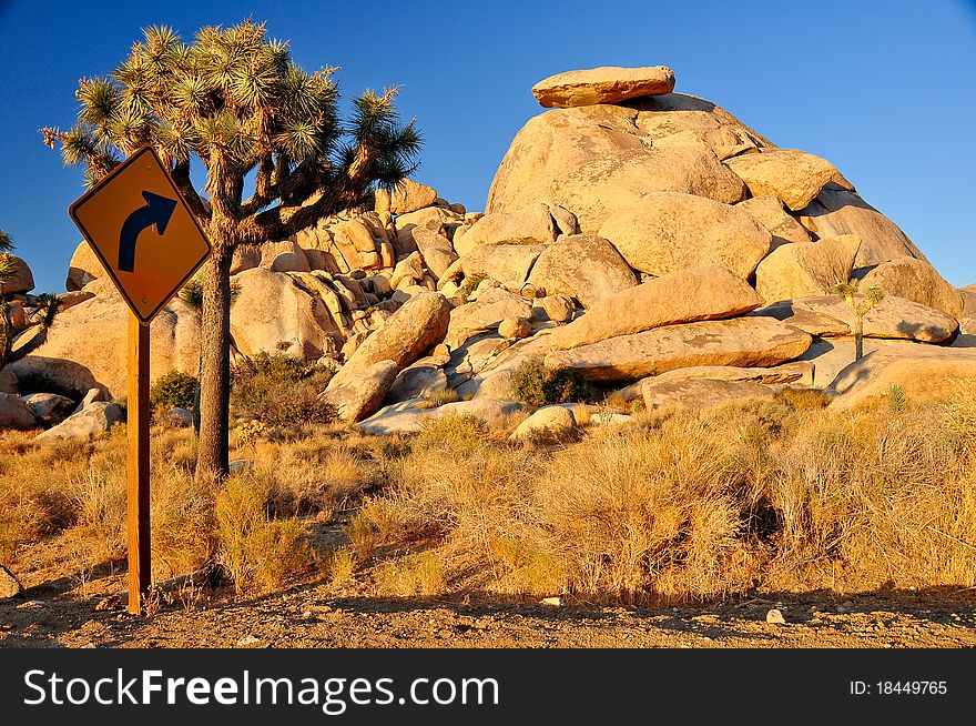 Road arrow sign pointing to rock in Joshua Tree national park