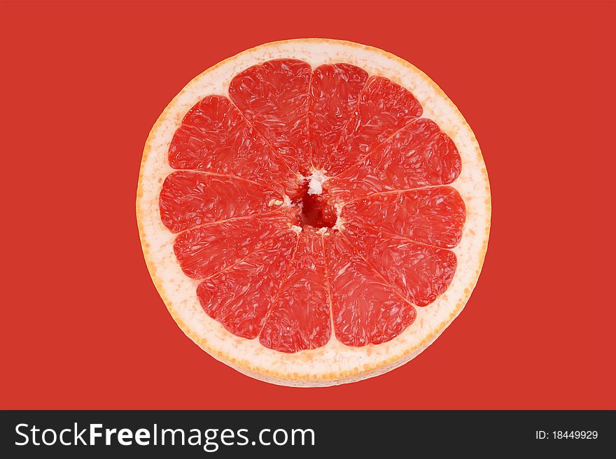 Ripe red grapefruit. Slice fruit on red background