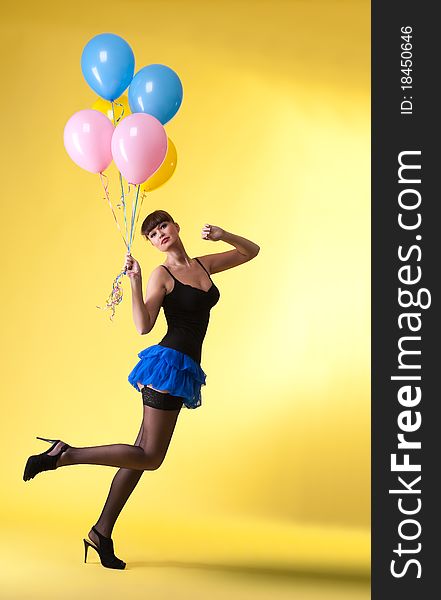 Pretty woman with balloons pinup style on yellow