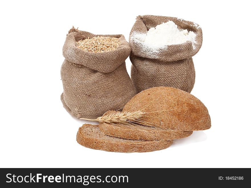 Flour and wheat grain with bread on white