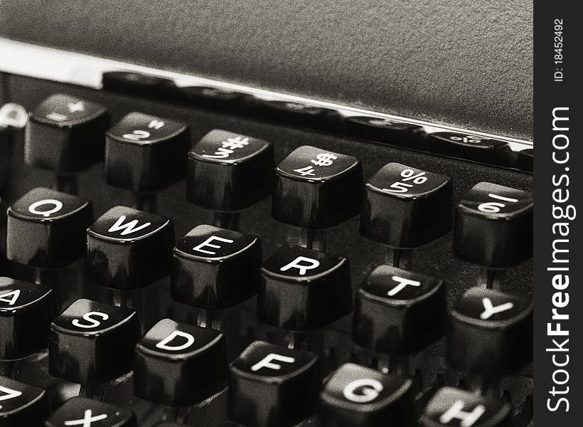 Vintage QWERTY keyboard. View of a vintage typewriter keys, with QWERTY keys visible. Image is black and white with heavy grain for vintage appearance.