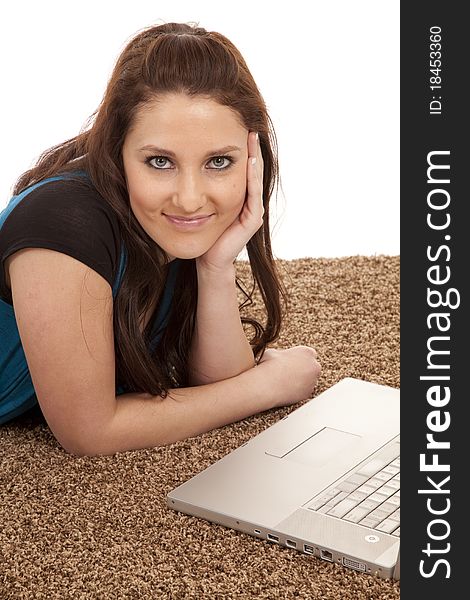 A woman is sitting by her laptop smiling. A woman is sitting by her laptop smiling