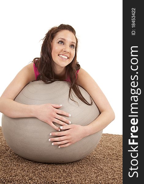 A woman is leaning on a large fitness ball. A woman is leaning on a large fitness ball