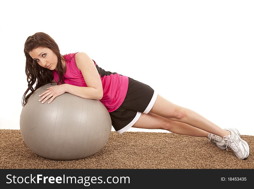 A woman is laying on her side on a big ball. A woman is laying on her side on a big ball.