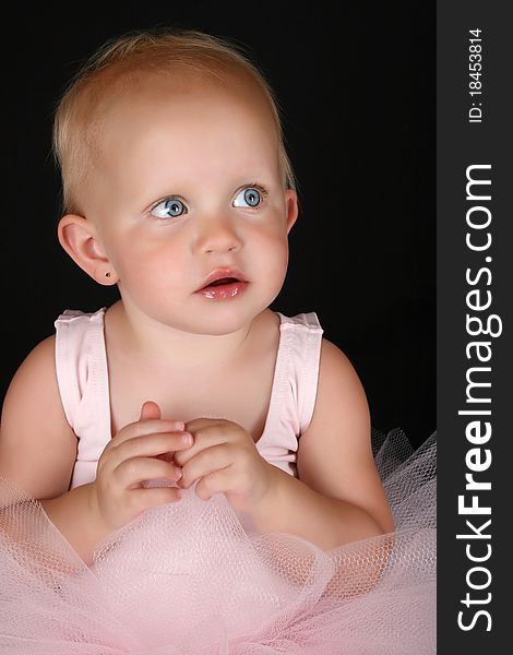 Cute blond baby ballerina looking into the distance