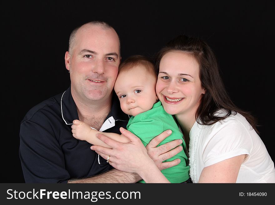 Family of three against a black background