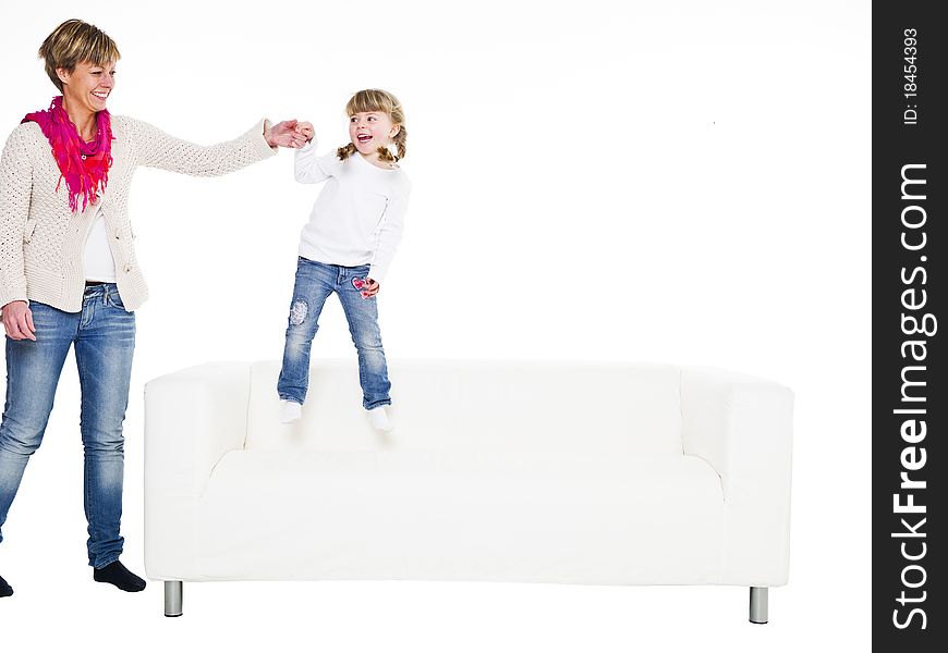 Young girl with her mother in a sofa isolated on white background. Young girl with her mother in a sofa isolated on white background