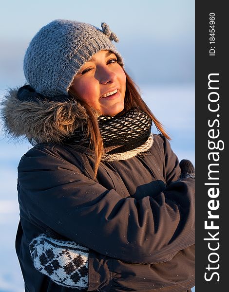 Portrait of a beautiful young girl in the sunlight in the cold