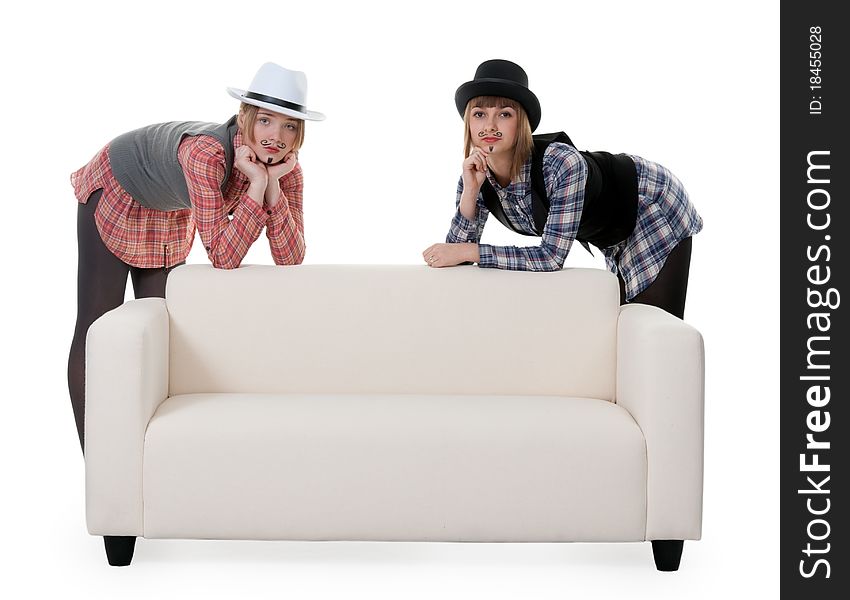 Two girls on the couch with a mustache painted on a white background