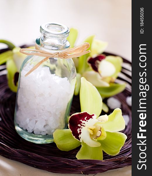 Jar of sea salt and flower on wood