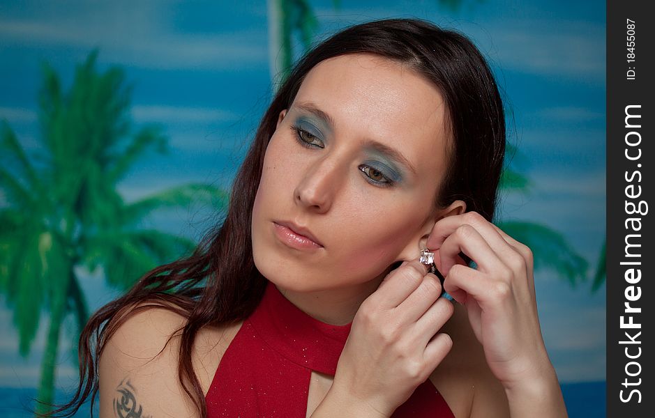 A portrait of woman putting on earrings