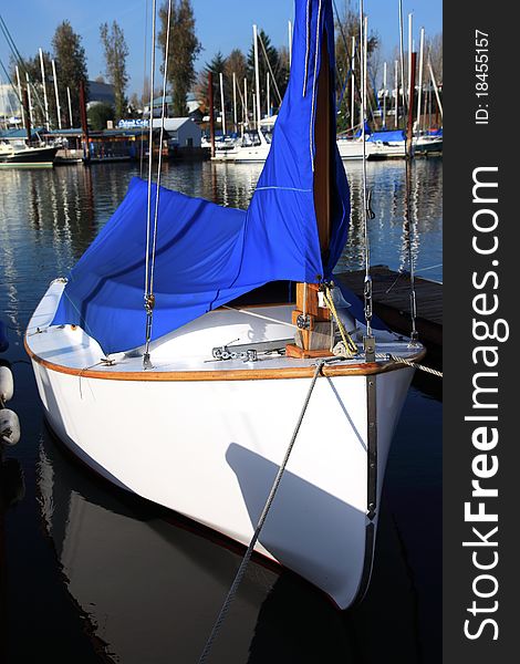 A small sailboat covered up for the winter in a marina. A small sailboat covered up for the winter in a marina.