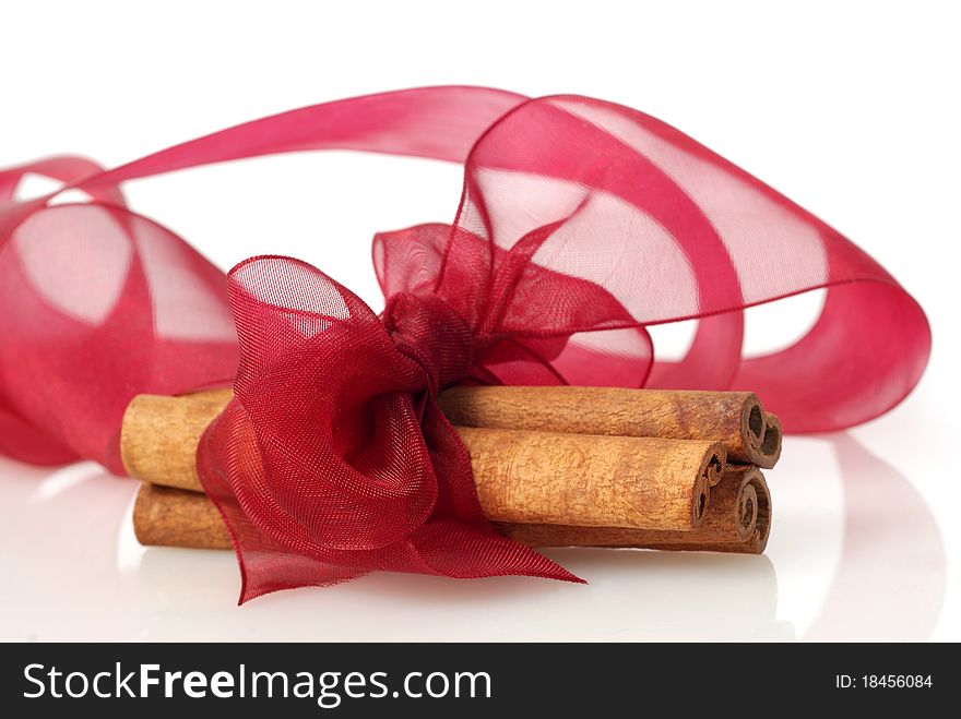 Cinnamon and red bow on white background