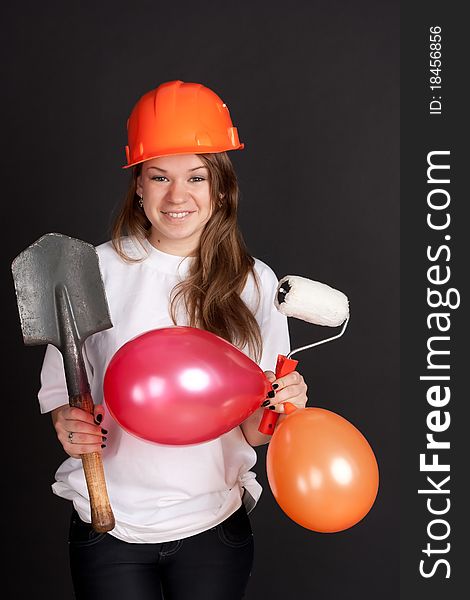 The girl in the helmet with balls and a shovel