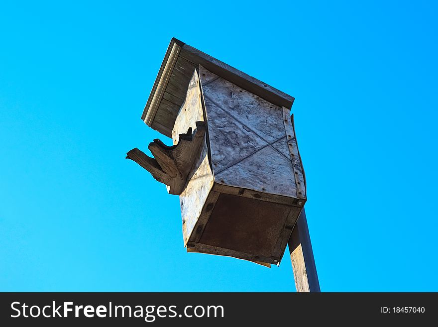 Very old bird house bright blue sky. Very old bird house bright blue sky