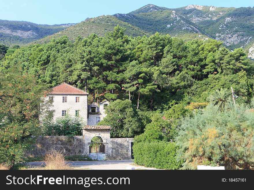 Traditional stone house in trees at the foot of a mountain. Traditional stone house in trees at the foot of a mountain