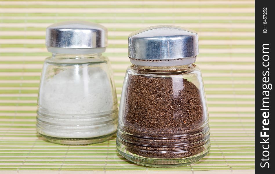Salt and pepper shaker on a green background