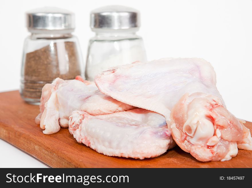 Raw chicken with salt and pepper. Isolated on a white background