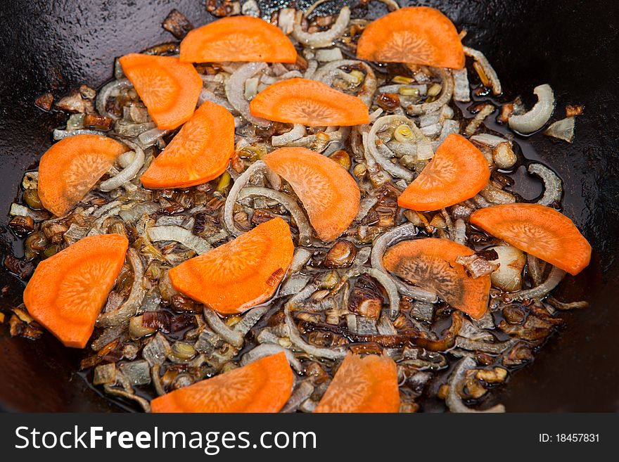 Carrot and onion are being boiled in pan