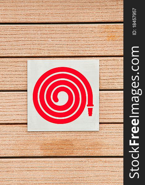 Fire hose symbol on a wooden background