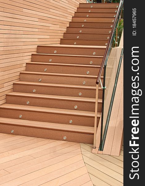 A portrait of outdoor wooden flooring and staircase. A portrait of outdoor wooden flooring and staircase