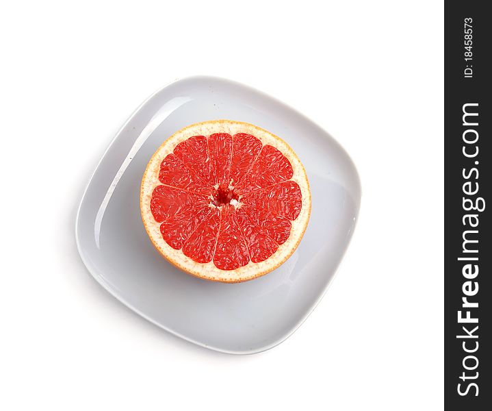 Ripe red grapefruit. The cut fruit on a blue plate