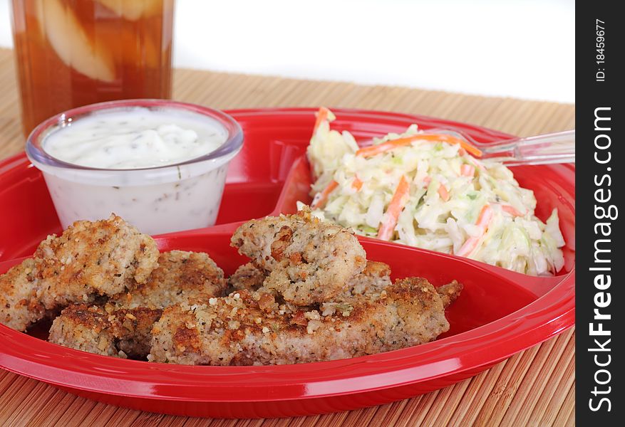 Chicken strips meal with coleslaw and sauce