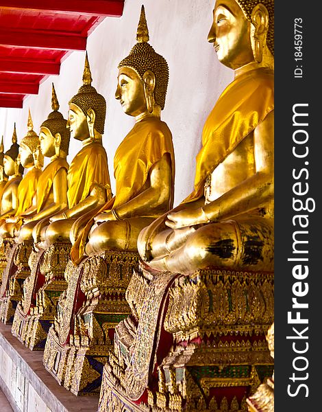 Golden sitting Buddha statues in Wat Mahathat Bangkok Thailand