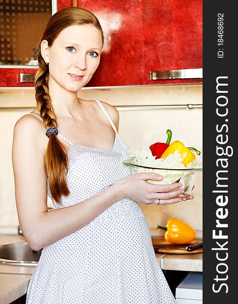 Pregnant Woman In Kitchen Making A Salad