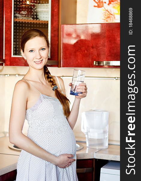 Pregnant Woman In Kitchen With Glass
