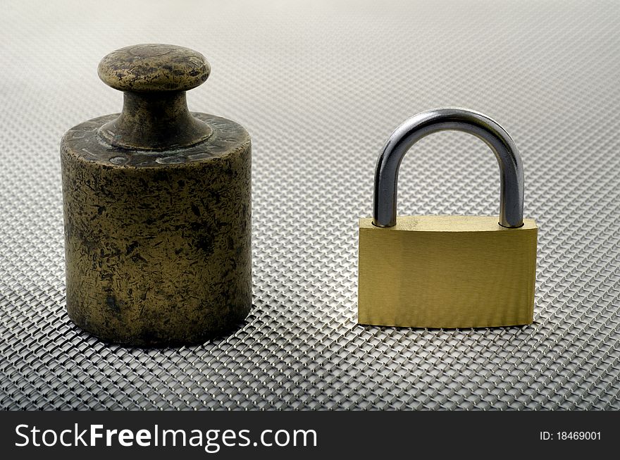 An old weight of bronze and a padlock. An old weight of bronze and a padlock