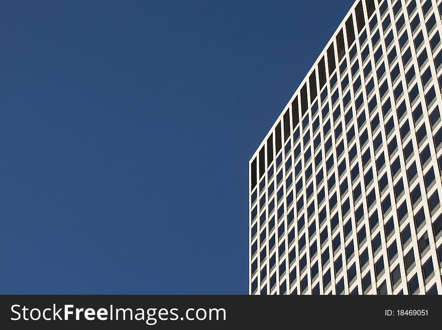 Looking up at a detail of a modern concrete and glass office building