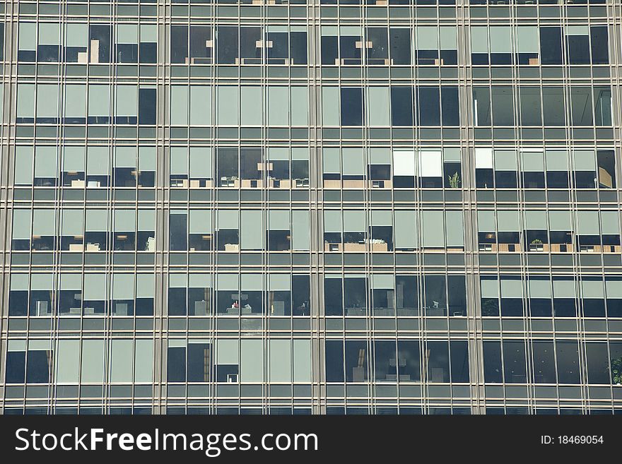 Looking up at a detail of a modern steel and glass office building. Window shades and furniture create an interesting pattern. Looking up at a detail of a modern steel and glass office building. Window shades and furniture create an interesting pattern.